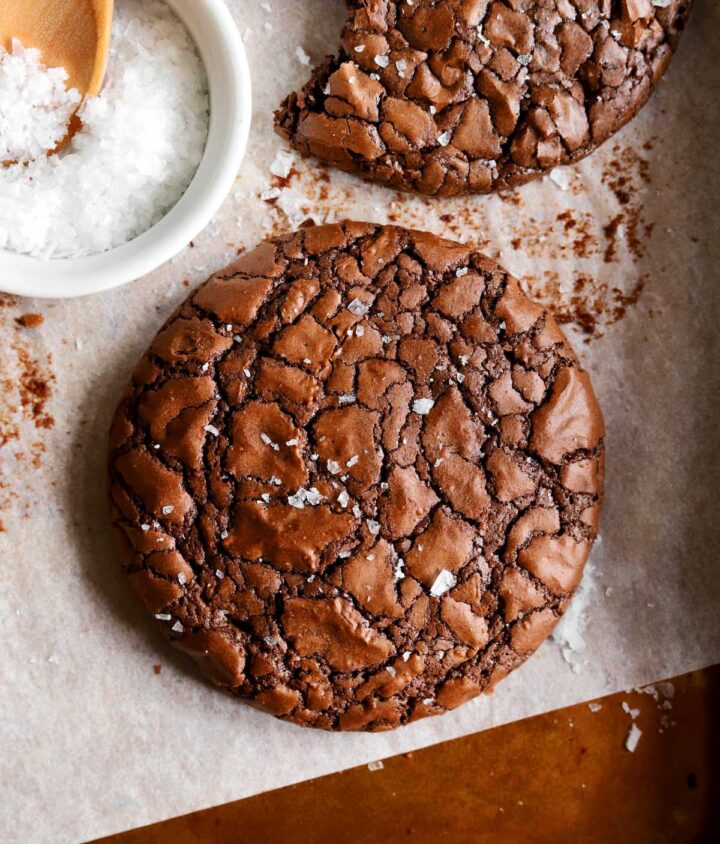 close up of chewy crinkle top brownie cookies on baking sheet
