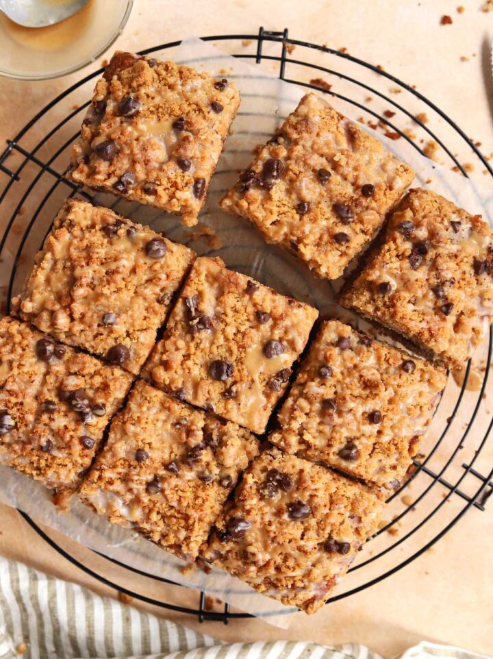 sliced chocolate chip banana bread coffee cake on cooling rack with spoon of espresso glaze