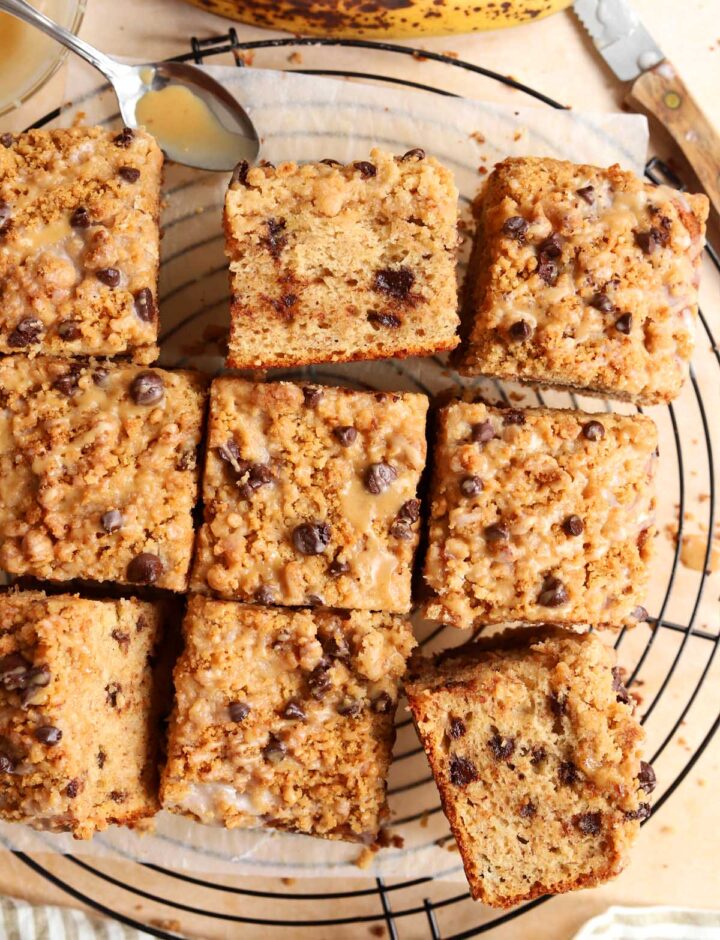 sliced chocolate chip banana bread coffee cake on cooling rack with spoon of espresso glaze
