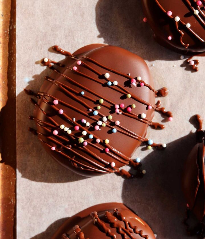 close up of Reese's chocolate peanut butter eggs dipped in chocolate on baking sheet