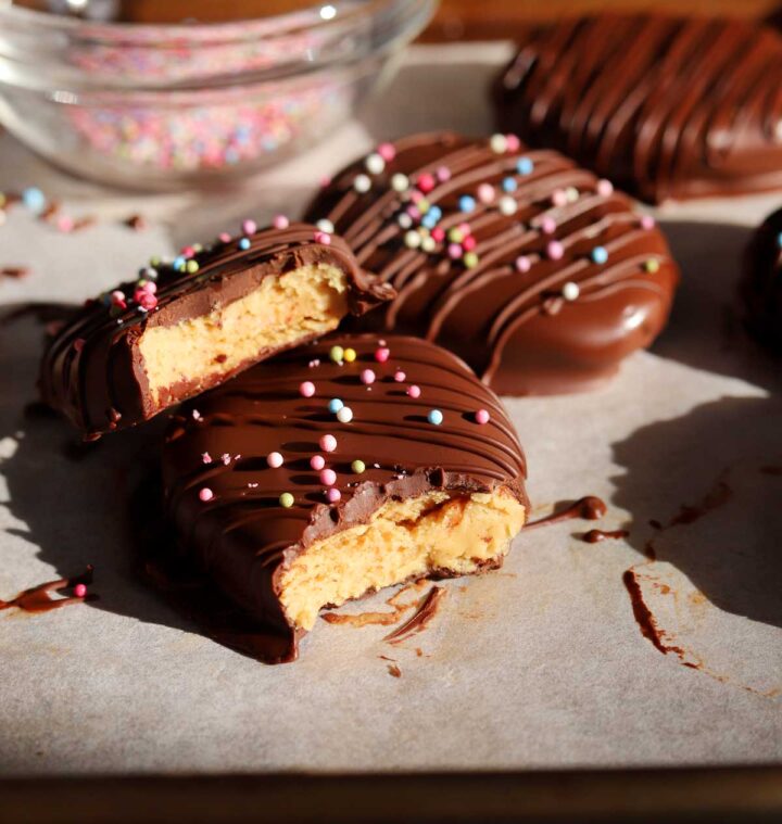 Reese's chocolate peanut butter eggs with bite showing smooth peanut butter filling