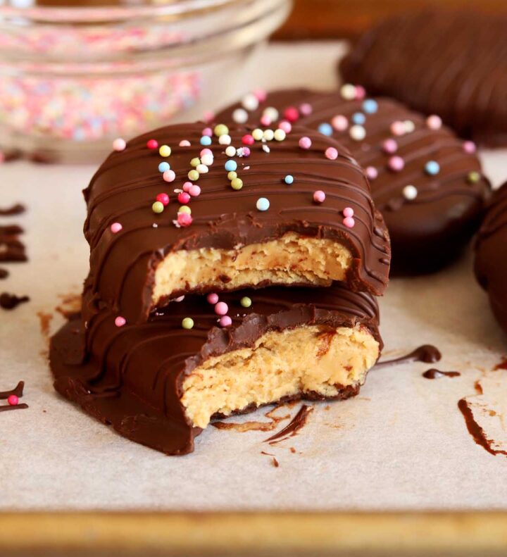 Reese's chocolate peanut butter eggs broken in half and stacked on baking sheet