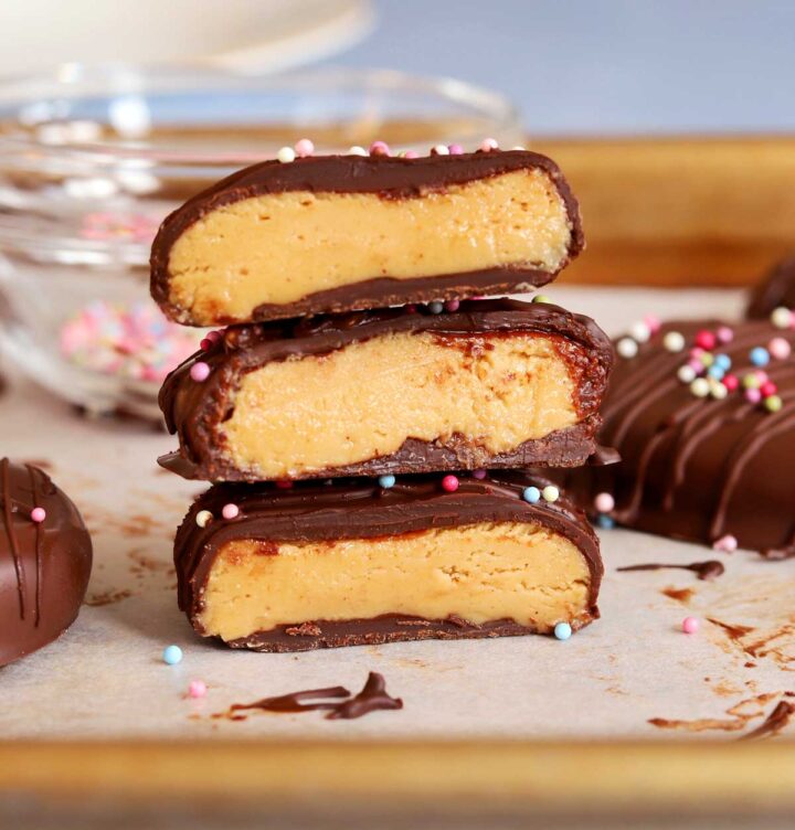 Reese's chocolate peanut butter eggs sliced in half and stacked on baking sheet