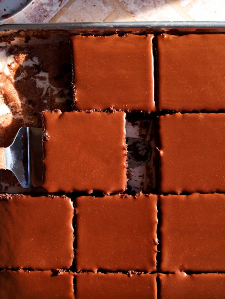 top view of chocolate sheet cake sliced in sheet pan with chocolate icing