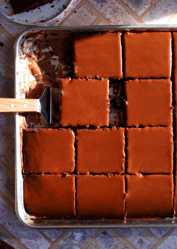top view of chocolate sheet cake sliced in sheet pan with cake server