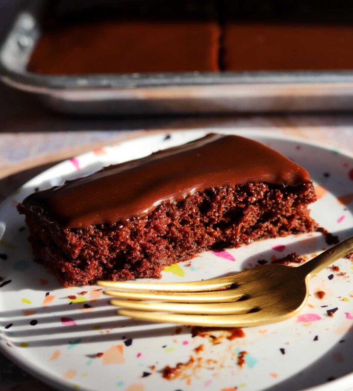 slice of chocolate Texas sheet cake on a plate with bite and fork