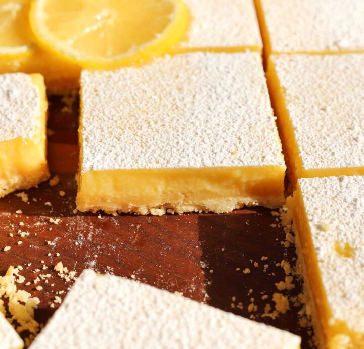 creamy lemon bars sliced on cutting board