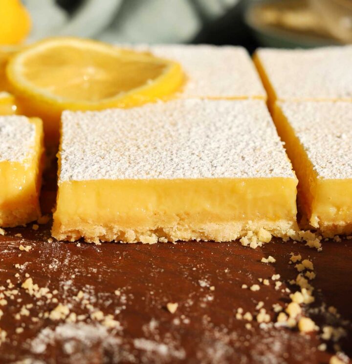 creamy lemon bars sliced on cutting board