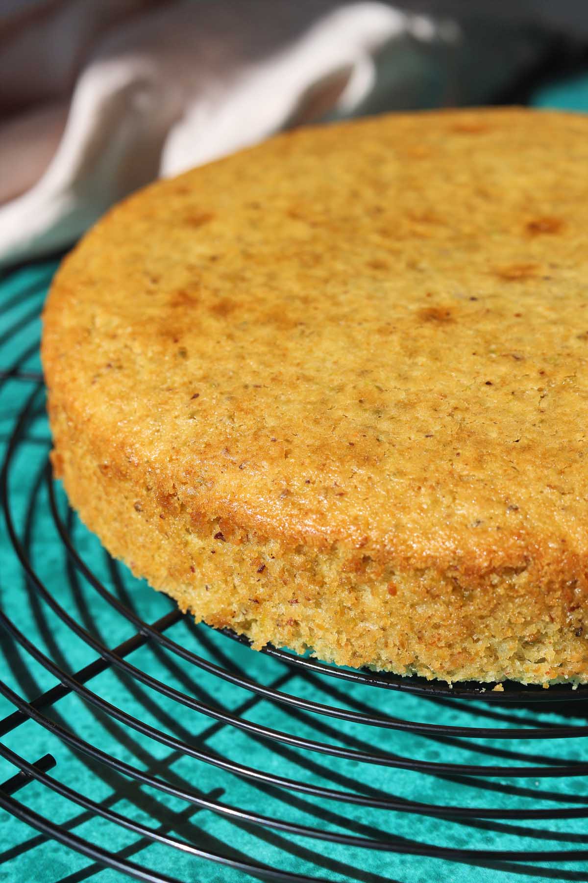 olive oil pistachio cake on a wire cooling rack