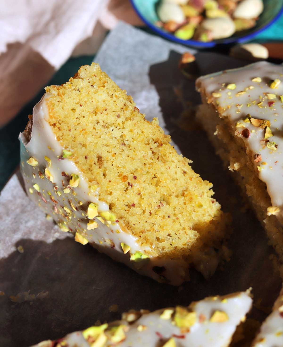 olive oil pistachio cake sliced on board