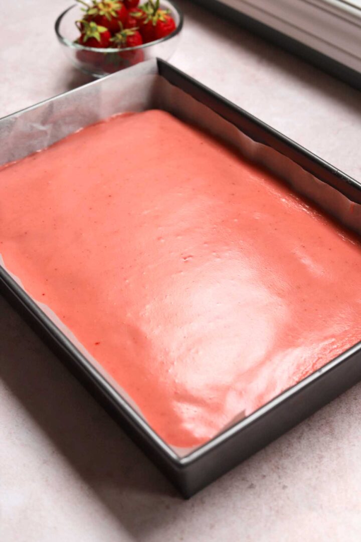 strawberry sheet cake in baking pan with strawberry icing