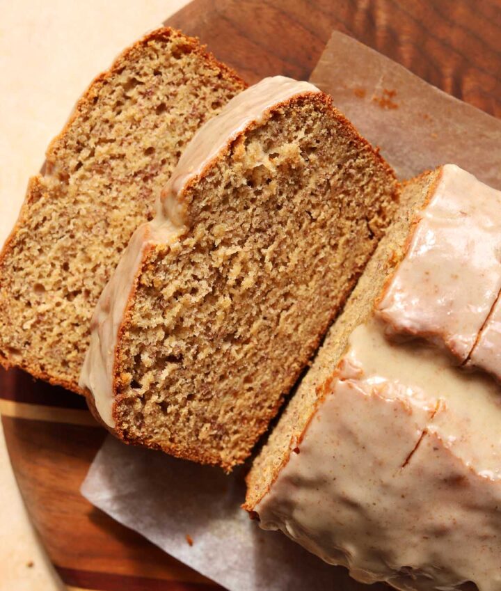 sliced brown butter banana bread on cutting board showing moist crumb texture