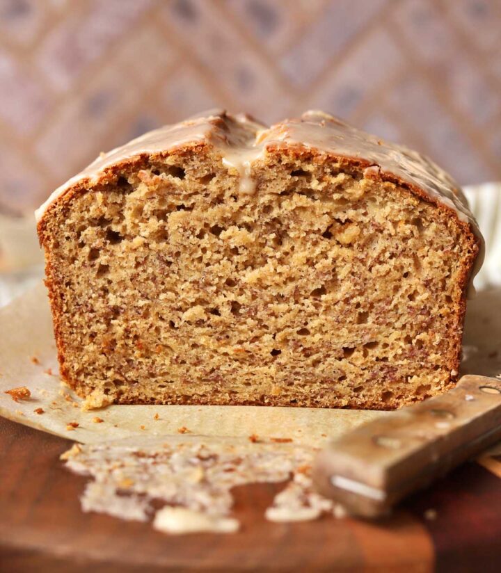 front view of sliced brown butter banana bread on cutting board showing moist crumb texture