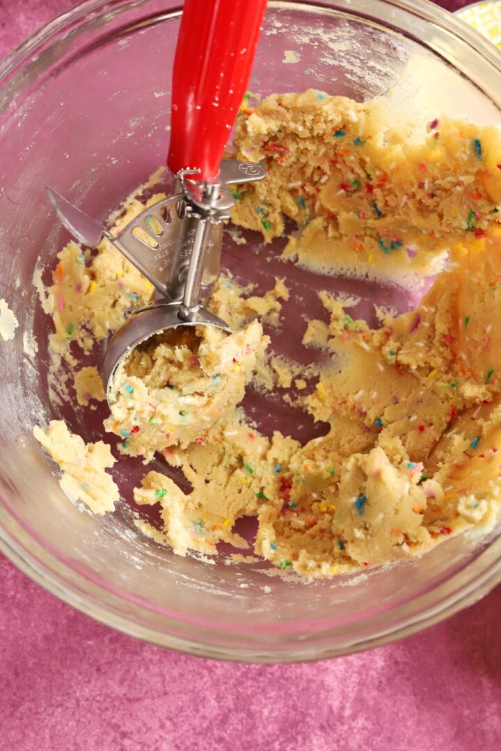 sprinkle sugar cookie dough in bowl with scoop