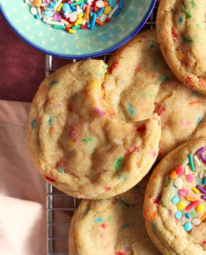 soft and chewy sprinkle sugar cookies with bite on cooling rack