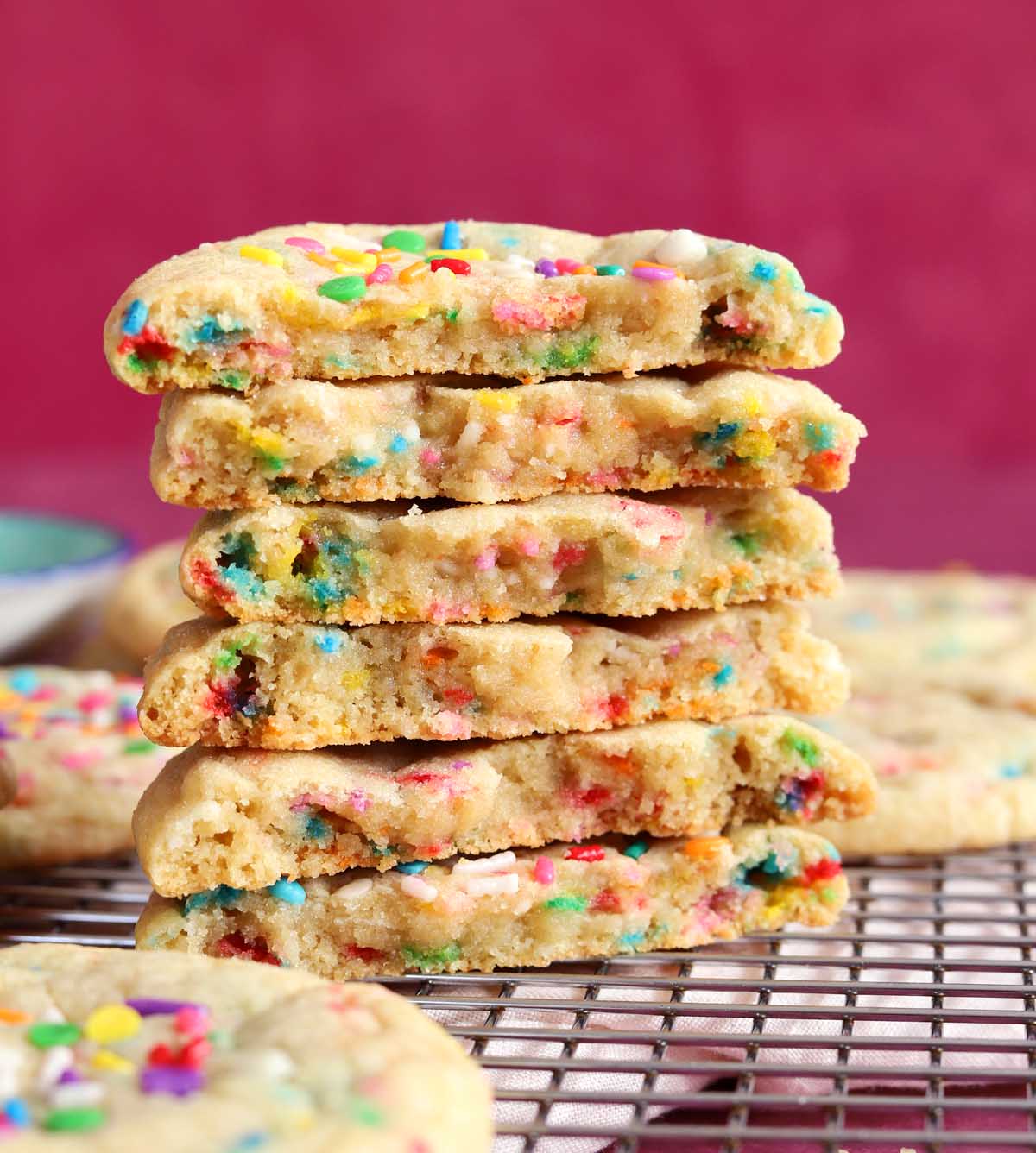 stack of sprinkle sugar cookies broken in half showing soft and chewy texture