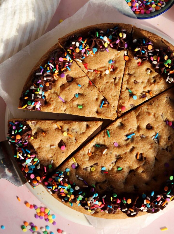 top view of chocolate chip cookie cake sliced with chocolate ganache frosting