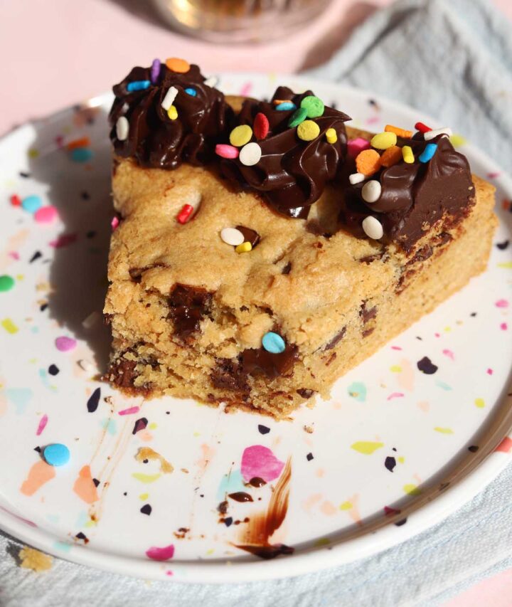 slice of chocolate chip cookie cake on a plate with bite
