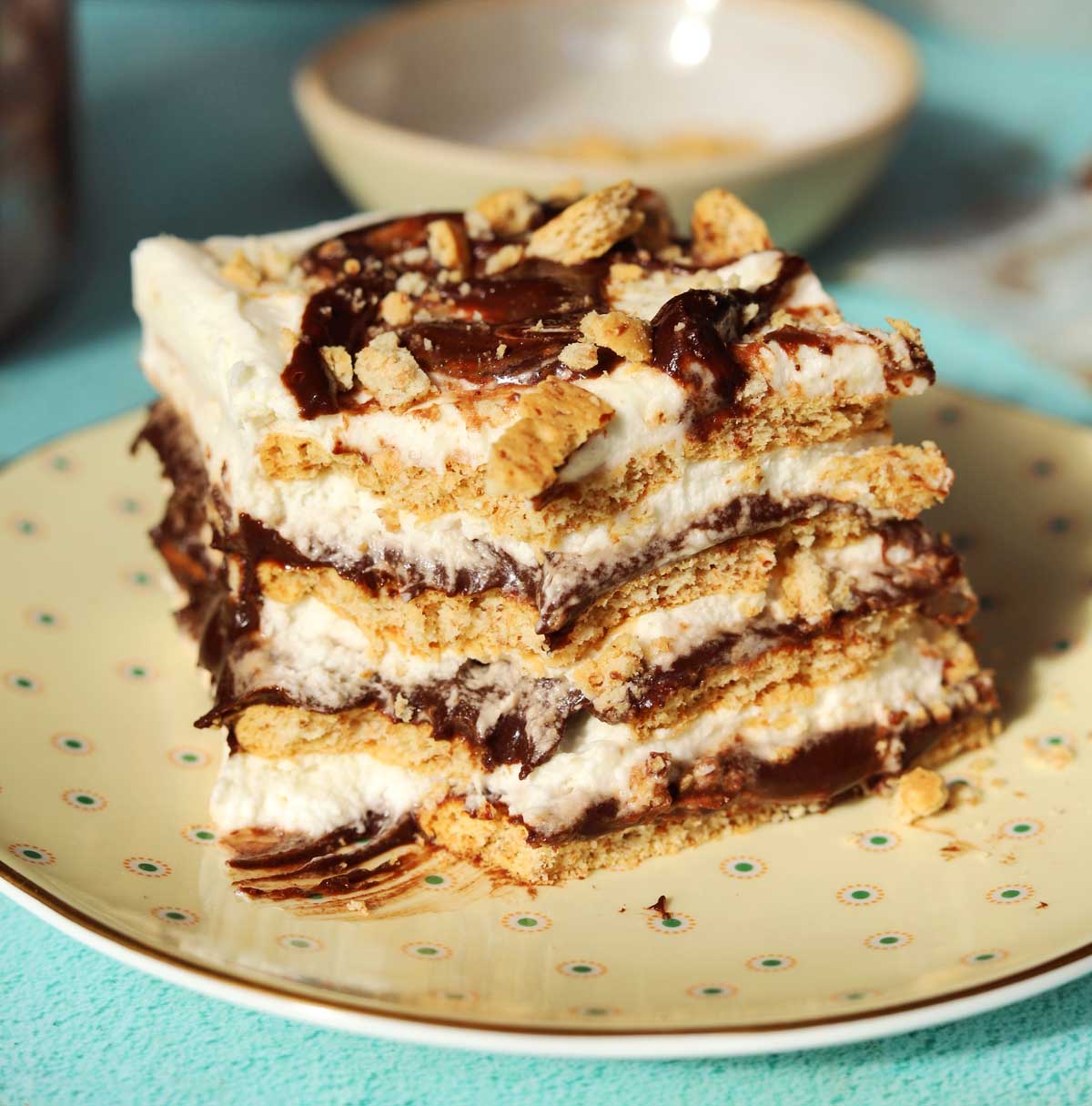 no bake s'mores icebox cake slice on a plate with bite