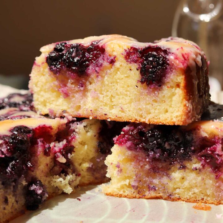 slices of lemon blueberry yogurt cake stacked on parchment