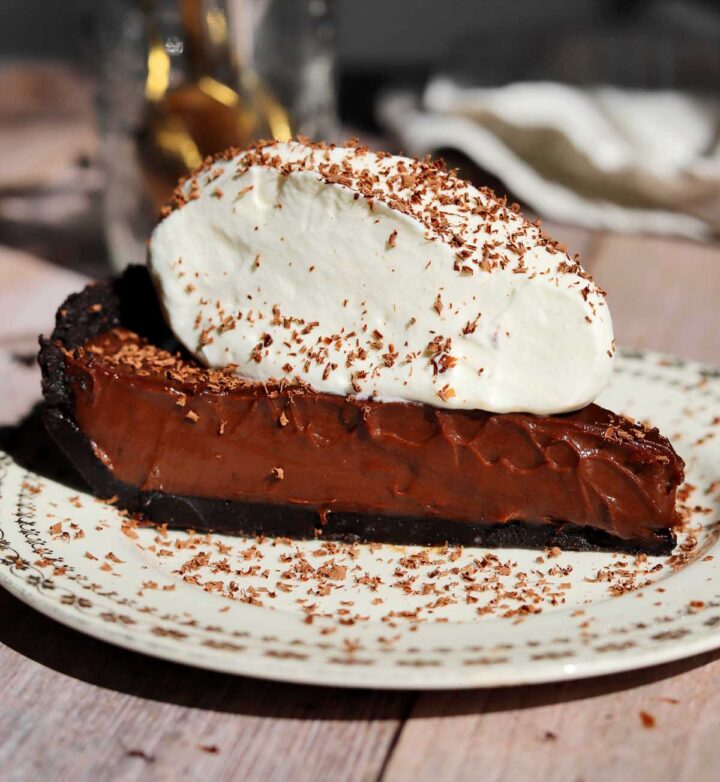 slice of no bake chocolate pie with whipped cream and chocolate shavings
