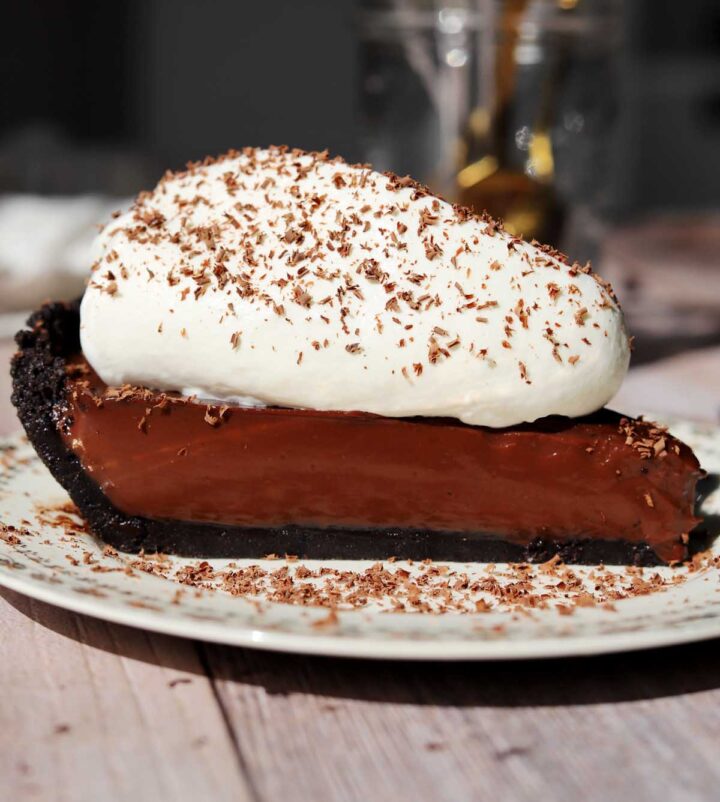 slice of no bake chocolate pie with whipped cream and chocolate shavings