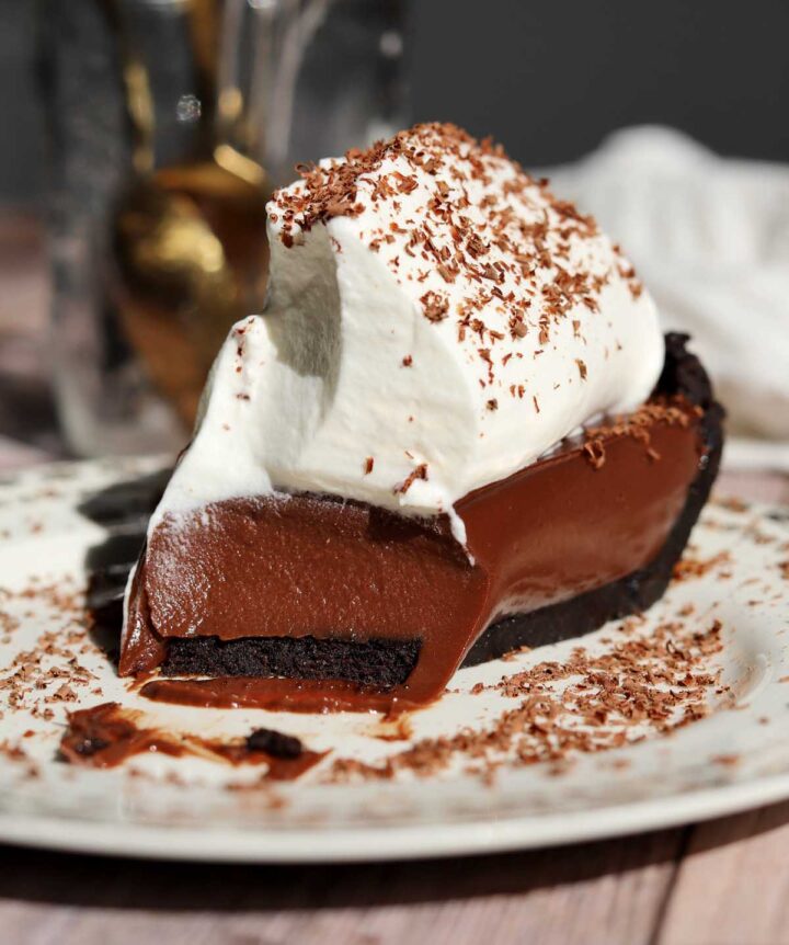 no bake chocolate pie with whipped cream on a plate with bite