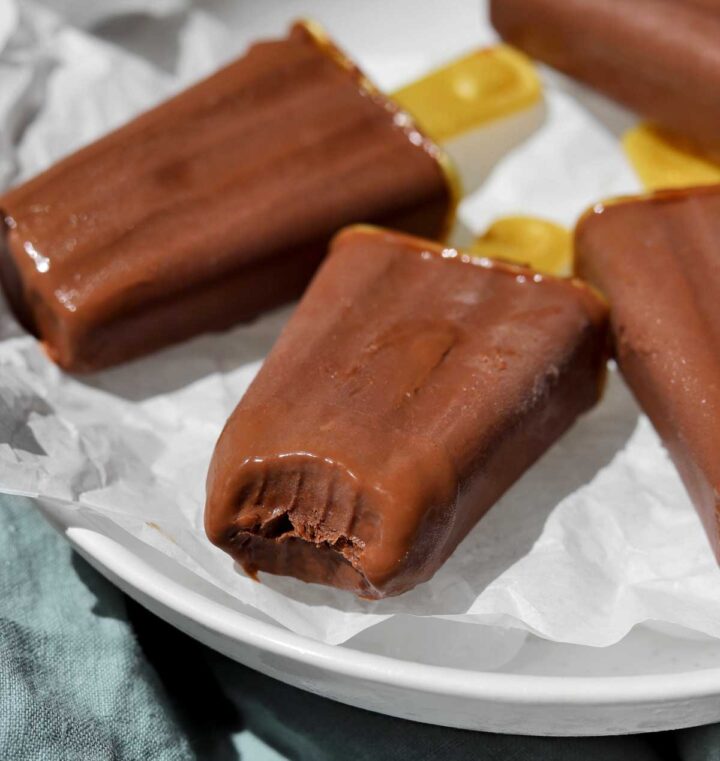 homemade fudgsicles on a plate over ice with a bite