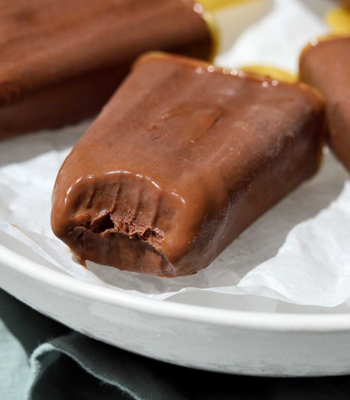 homemade fudgsicles on a plate over ice with a bite
