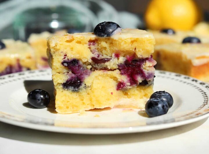 fudgy lemon blueberry brownies split in half showing fudgy texture on a plate
