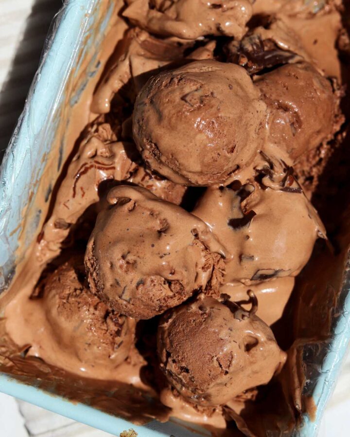 no churn chocolate crackle ice cream in loaf pan with scoops portioned