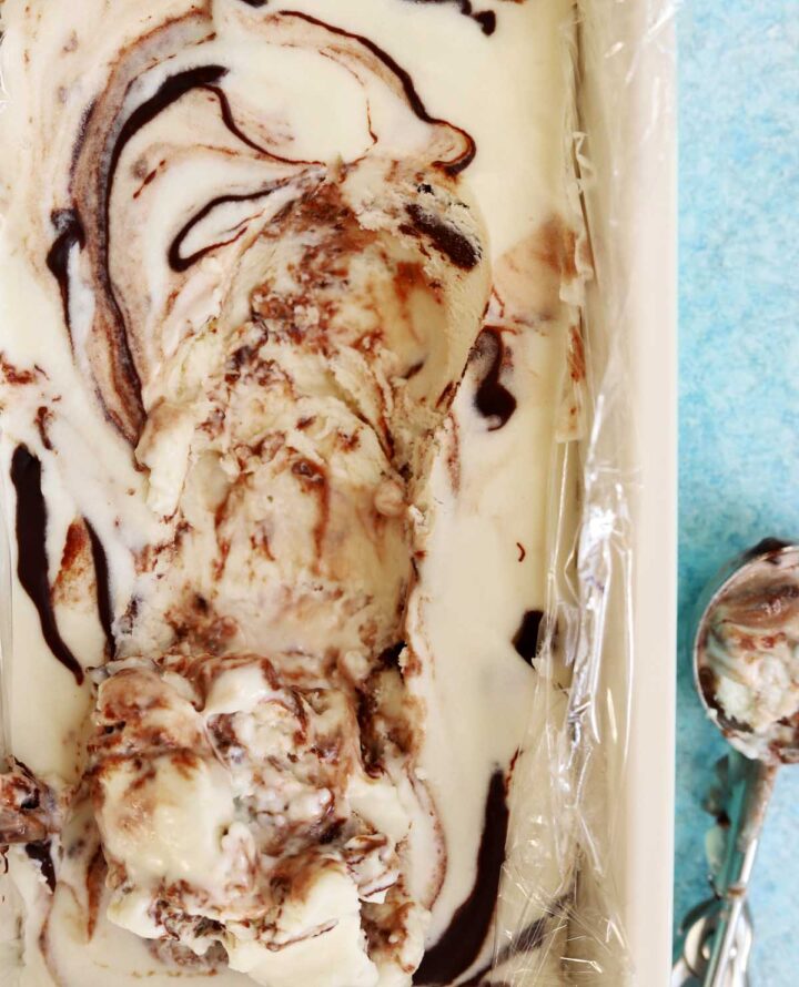 no churn chocolate fudge swirl peppermint cheesecake ice cream in loaf pan with ice cream scoop