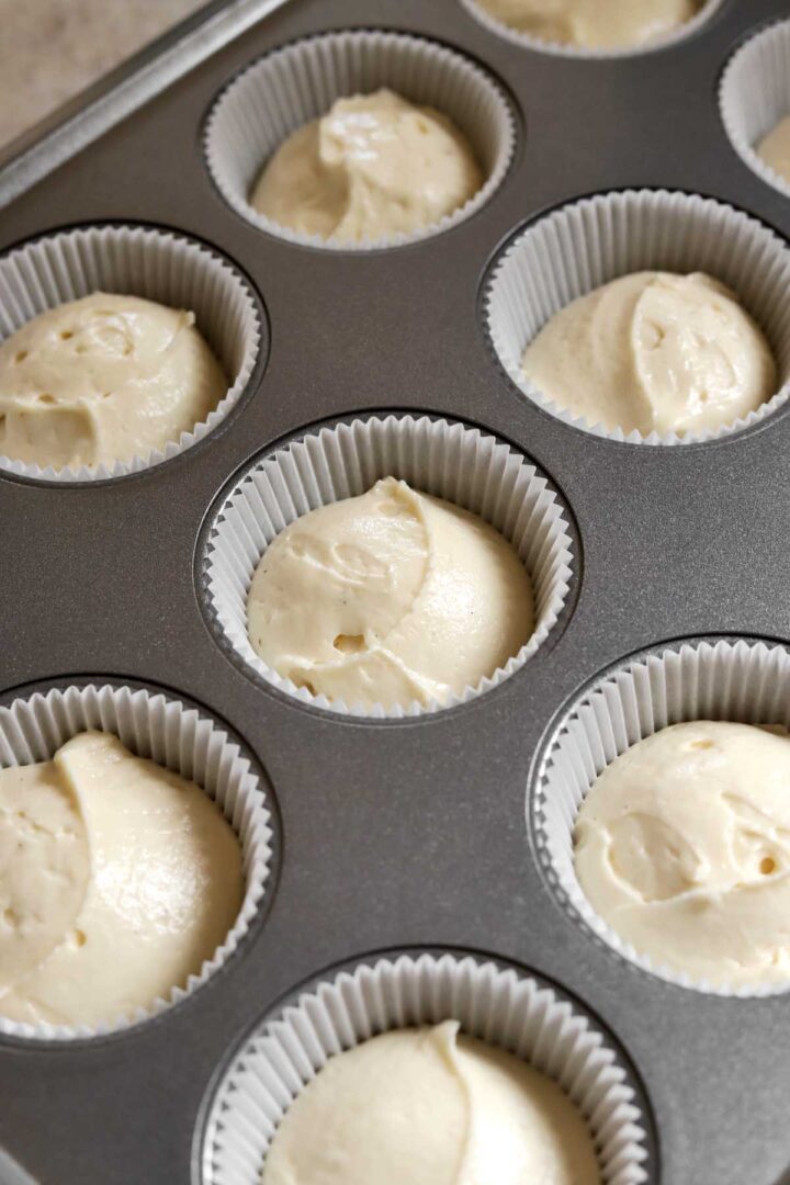 vanilla cupcake batter in paper liners in baking pan