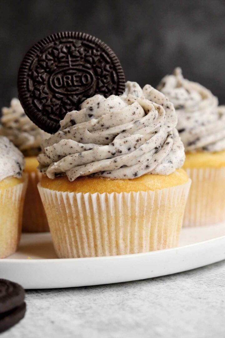 Oreo cookies and cream cupcakes on a plate with Oreo cookie in buttercream