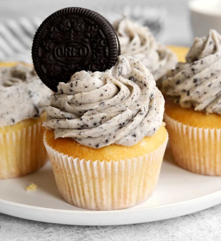 Oreo cookies and cream cupcakes on a plate with Oreo cookie in buttercream