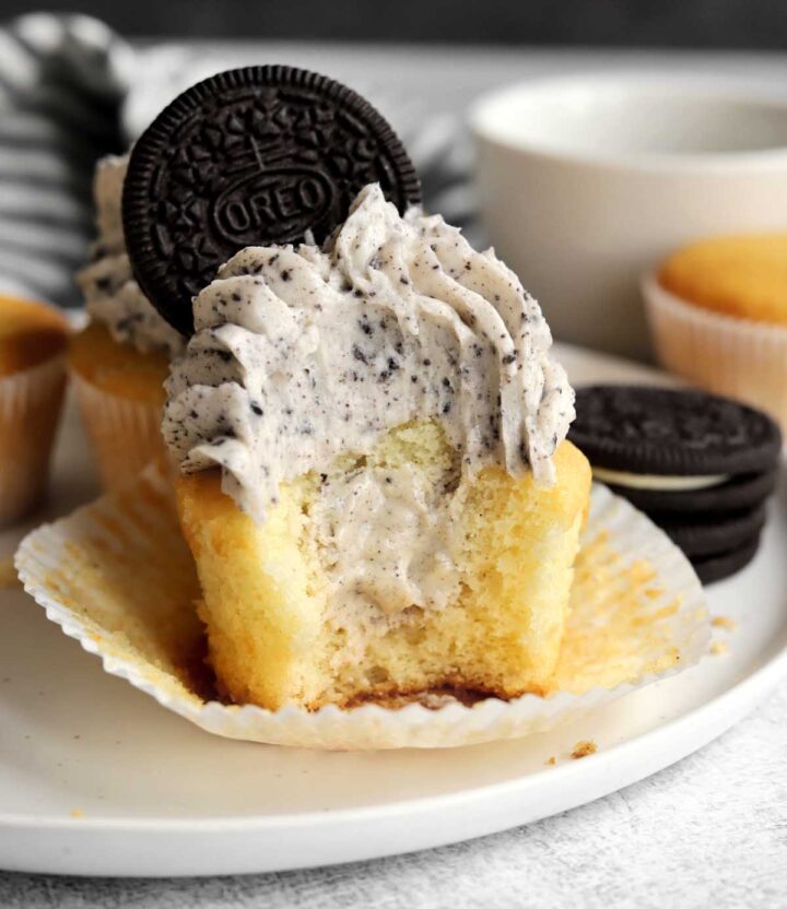 Oreo cookies and cream cupcakes with bite showing creamy white chocolate ganache filling