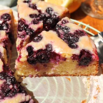 lemon blueberry yogurt cake with glaze sliced on cooling rack