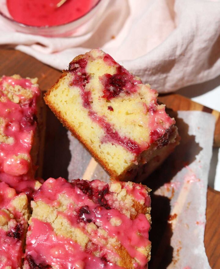 top view of raspberry lemonade coffee cake slice on serving board showing cross section with raspberry swirl