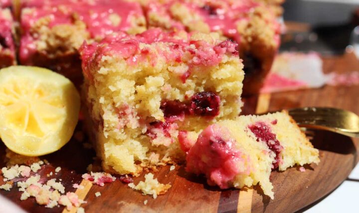 raspberry lemonade coffee cake on serving board with bite and fork