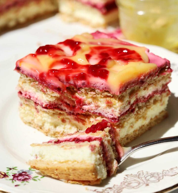 raspberry lemonade icebox cake slice on a plate with bite and fork