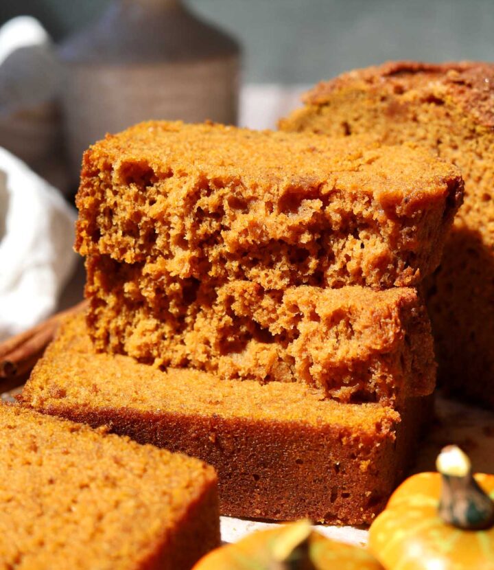 the best pumpkin bread slice broken in half and stacked showing moist crumb texture