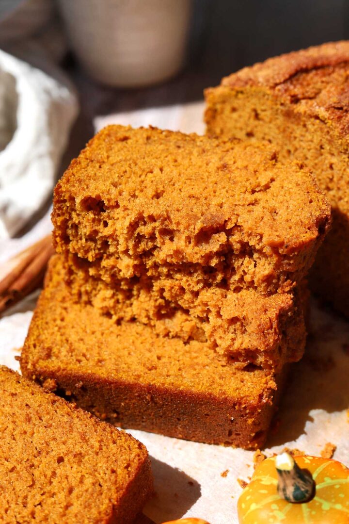 the best pumpkin bread slice broken in half and stacked showing moist crumb texture