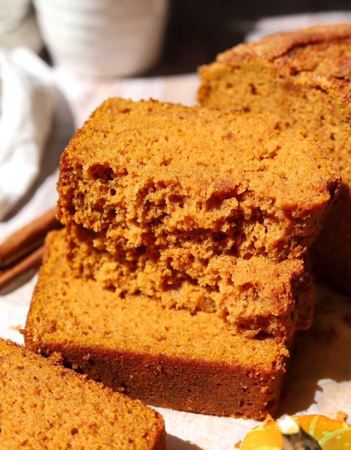 the best pumpkin bread slice broken in half and stacked showing moist crumb texture