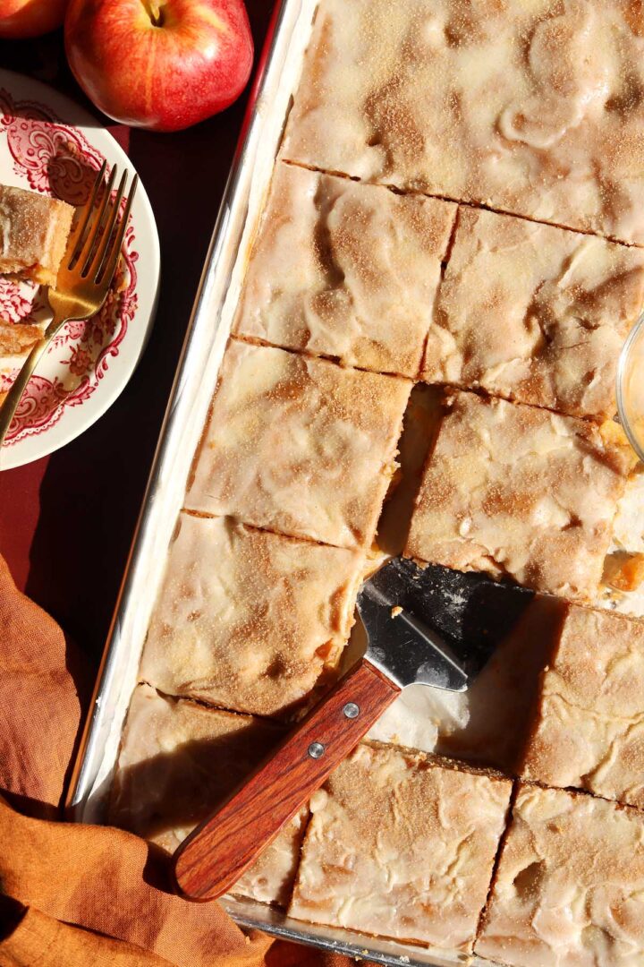 top view of apple fritter Texas sheet cake in baking sheet pan with serving spatula
