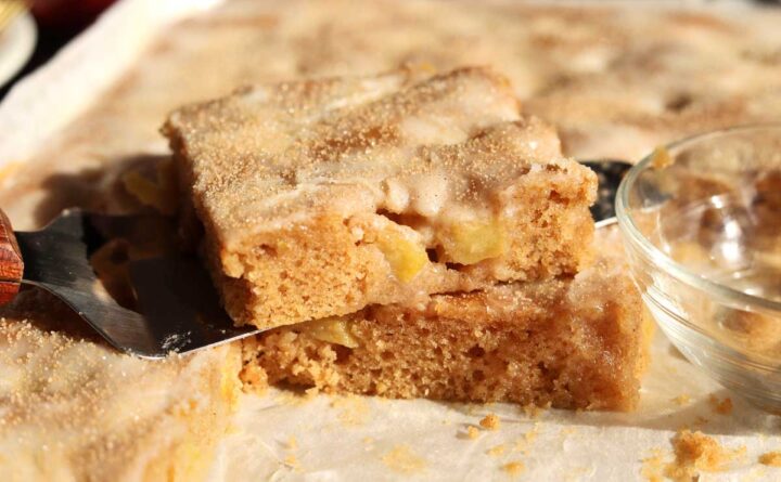 apple fritter Texas sheet cake in baking sheet pan with slice cut out on top