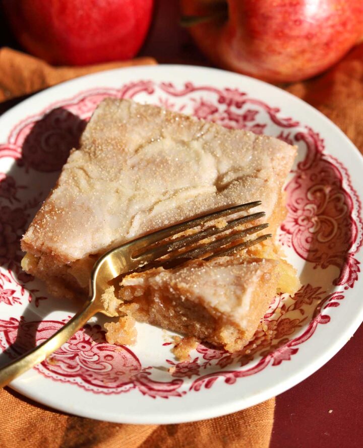 slice of apple fritter Texas sheet cake on a plate with bite and fork