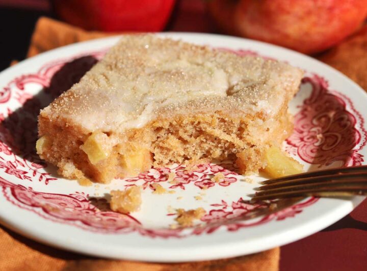 slice of apple fritter Texas sheet cake on a plate with bite and fork