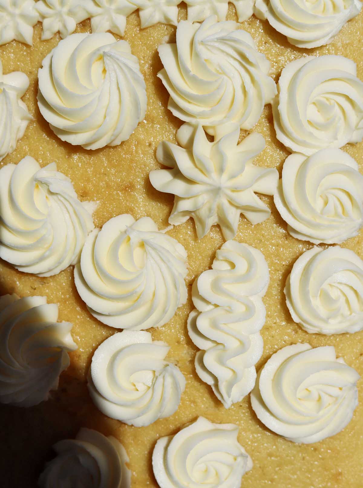 moist vanilla sheet cake with vanilla buttercream decorations piped on top