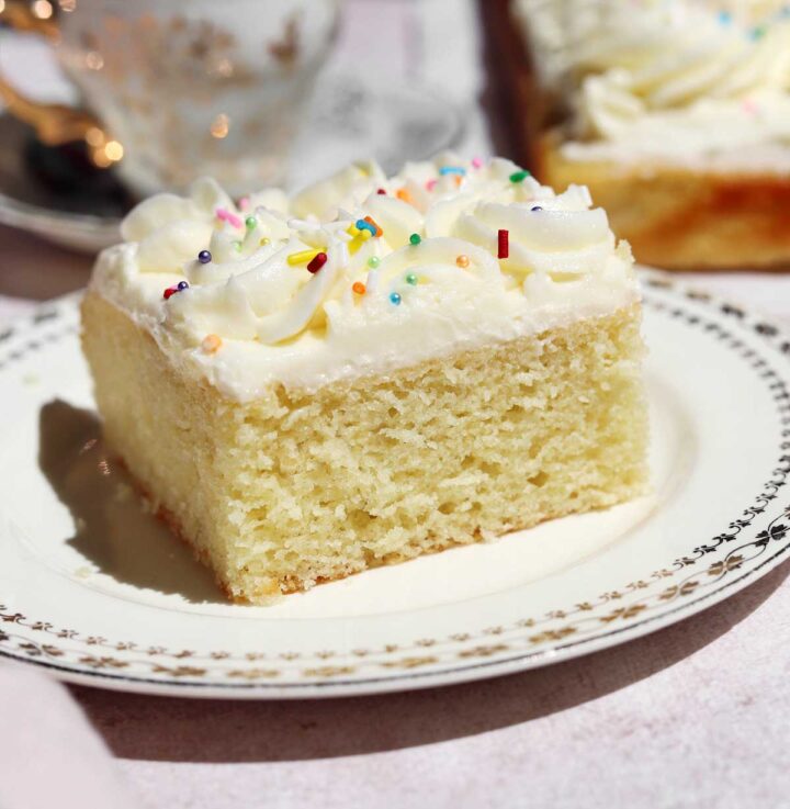 slice of moist vanilla sheet cake on a plate