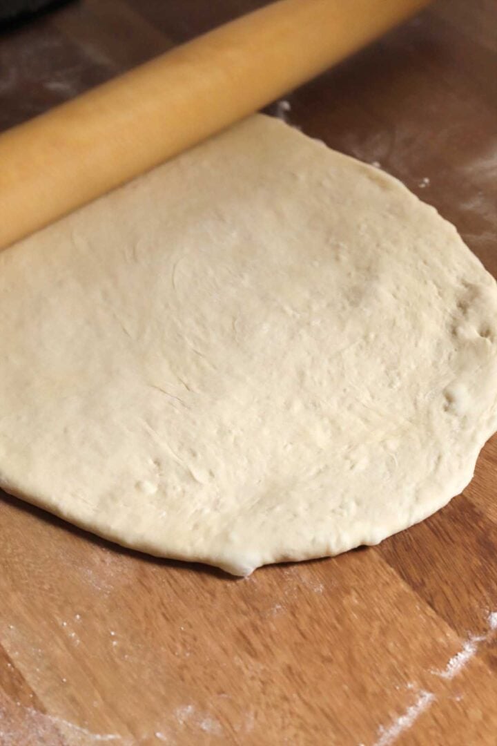 homemade pizza dough rolled out for second proof to make pizza